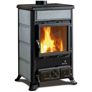 La Nordica Küchenherd Rosa mit Natursteinverkleidung und Feuer im Brennraum.