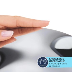 Detailaufnahme: Finger berührt die glänzende, verchromte Oberfläche der Grohe QuickFix Handdusche.