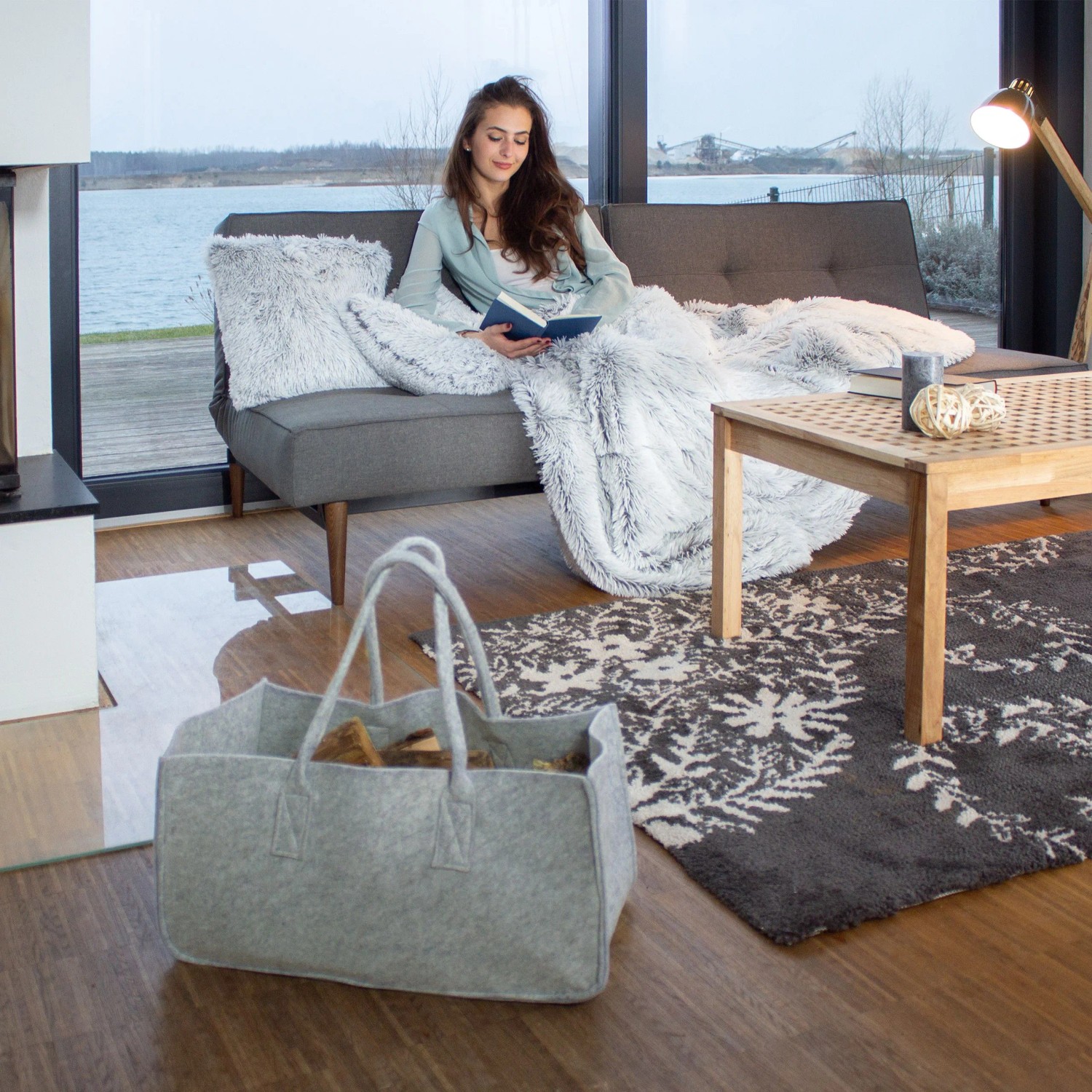 Helle Filz Kaminholztasche mit Henkeln, gefüllt mit Brennholz, im Wohnzimmer. Zubehör für Kamine & Öfen.