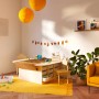 Kinderzimmer mit elfenbeinweißer Wandfarbe von CREATE! by OBI, gelbem Teppich und Spieltisch.