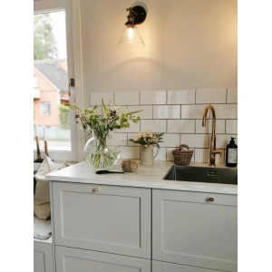 PR Home Lambda Wandleuchte aus Glas und Metall in einem Badezimmer.