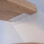Detailaufnahme einer Buchenholz-Stufe der Treppe Kos mit weißem Metallgeländer.