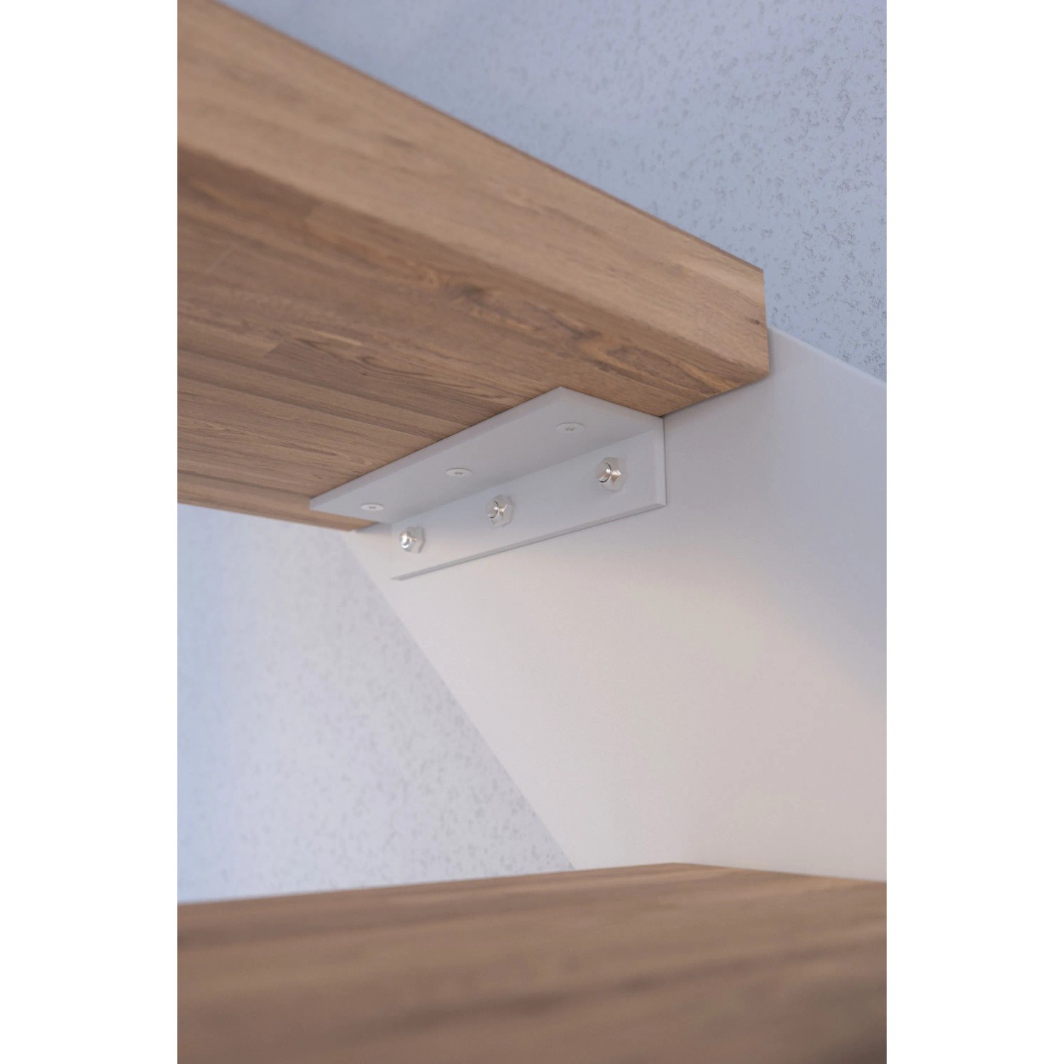 Detailaufnahme einer Buchenholz-Stufe der Treppe Kos mit weißem Metallgeländer.