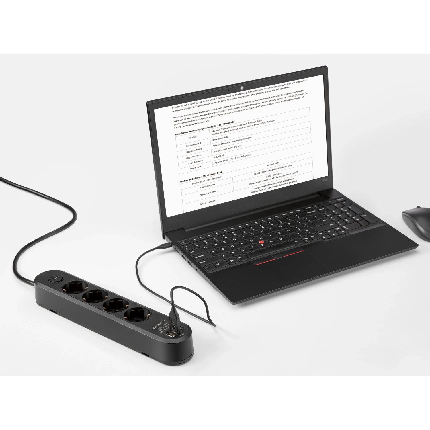 Schwarze 4-fach Steckdosenleiste mit USB-Anschlüssen und Laptop.