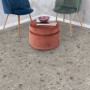 Verlegter Egger Aqua-Laminatboden Triestino Terrazzo Grau mit Möbeln im Raum.