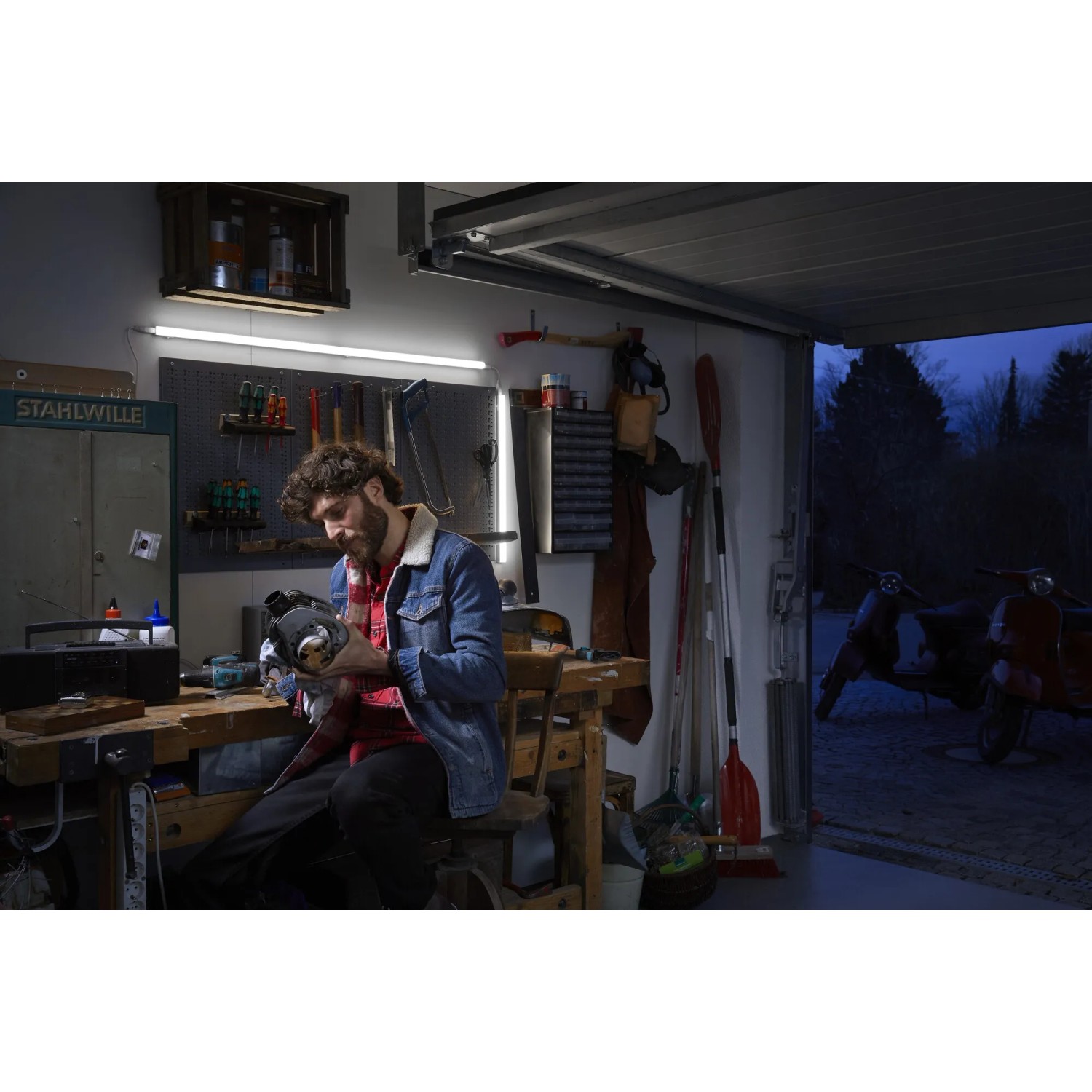 Mann arbeitet unter Ledvance LED-Lichtleiste Switch Batten in Werkstatt/Garage.