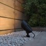 Schwarze Philips Cylr LED Erdspießleuchte im Garten zwischen weißen Steinen.