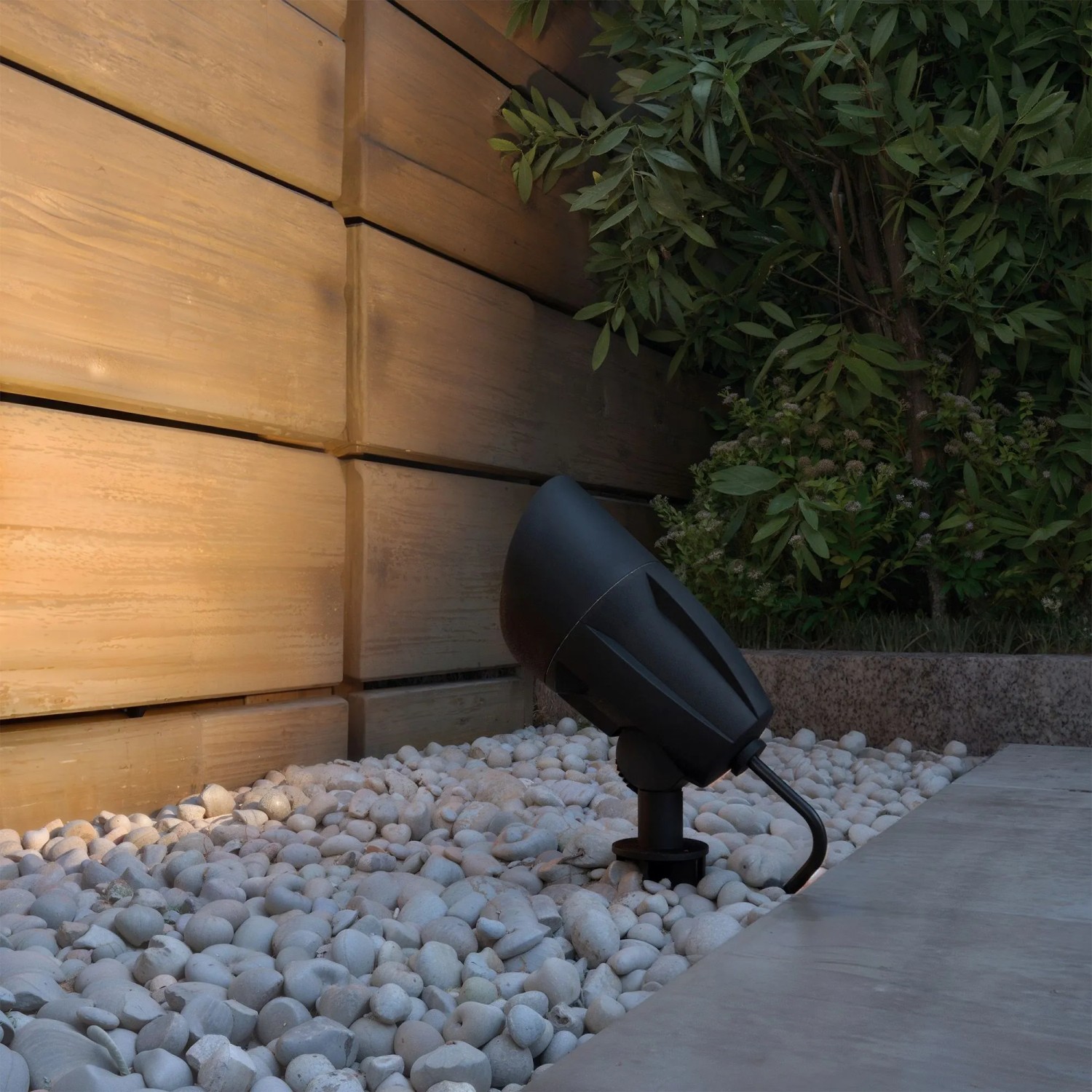Schwarze Philips Cylr LED Erdspießleuchte im Garten zwischen weißen Steinen.