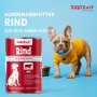 Rote Dose Supravit Hundenassfutter Rind neben einem French Bulldog Welpen in gelbem Shirt auf blauem Grund.