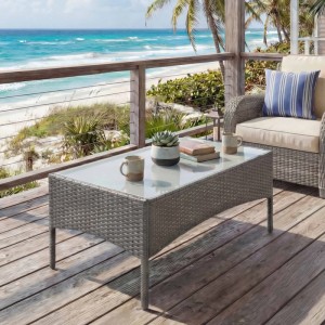 Grauer MCW Poly-Rattan Gartentisch Hamar mit Glasplatte auf Holzterrasse, dekoriert mit Tassen und Pflanze.