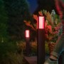 Philips Hue Impress LED-Wegeleuchte, schwarz, mit rotem Licht im Garten.