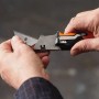 Hände bedienen Fiskars Universal-Klappmesser CarbonMax. Messer mit ausgefahrener Klinge.