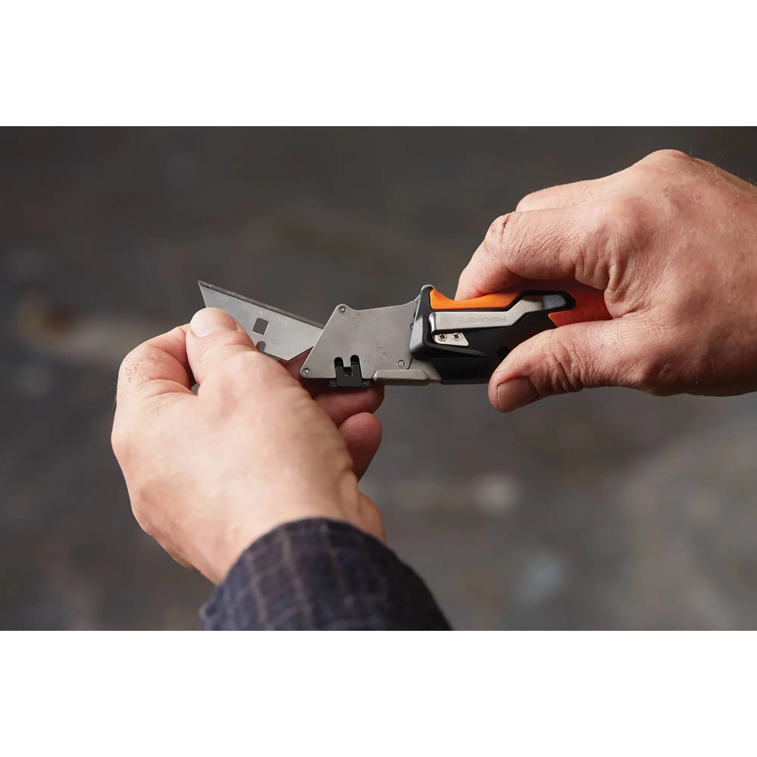 Hände bedienen Fiskars Universal-Klappmesser CarbonMax. Messer mit ausgefahrener Klinge.