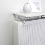 Weisse OBI Heizkörperkonsole mit Regalbrett über Heizkörper, dekoriert mit Vase und Bilderrahmen.