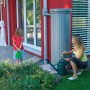 Garantia Regenwassertank 330 l Steingrau mit Wasserentnahme und spielendem Kind im Garten.