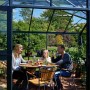 Juliana Gewächshaus Orangerie 15 in Schwarz-Anthrazit mit Familie beim Essen im Inneren.