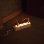 Weiße Shelly Power Strip 4 Gen 4 smarte Steckdosenleiste mit vier Steckdosen und zwei eingesteckten Geräten.