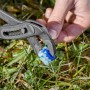 Gardena Verbinder wird mit einer Zange auf Rasen fixiert, Zubehör für Mähroboter.
