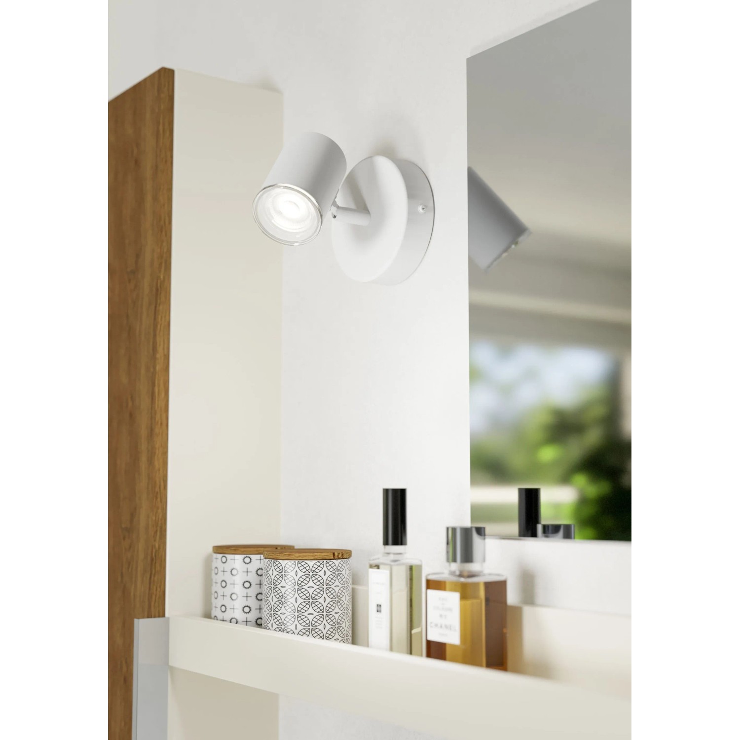 Weiße Eglo Consuma 1 Wandleuchte, drehbarer Spot, leuchtet an weißer Wand über Regal. IP44 Spritzwasserschutz für Bad, Flur.
