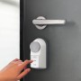 Burg-Wächter secuENTRY active 7700 Tür-Motorschloss in Weiß mit Finger auf Bedienfeld an Tür.