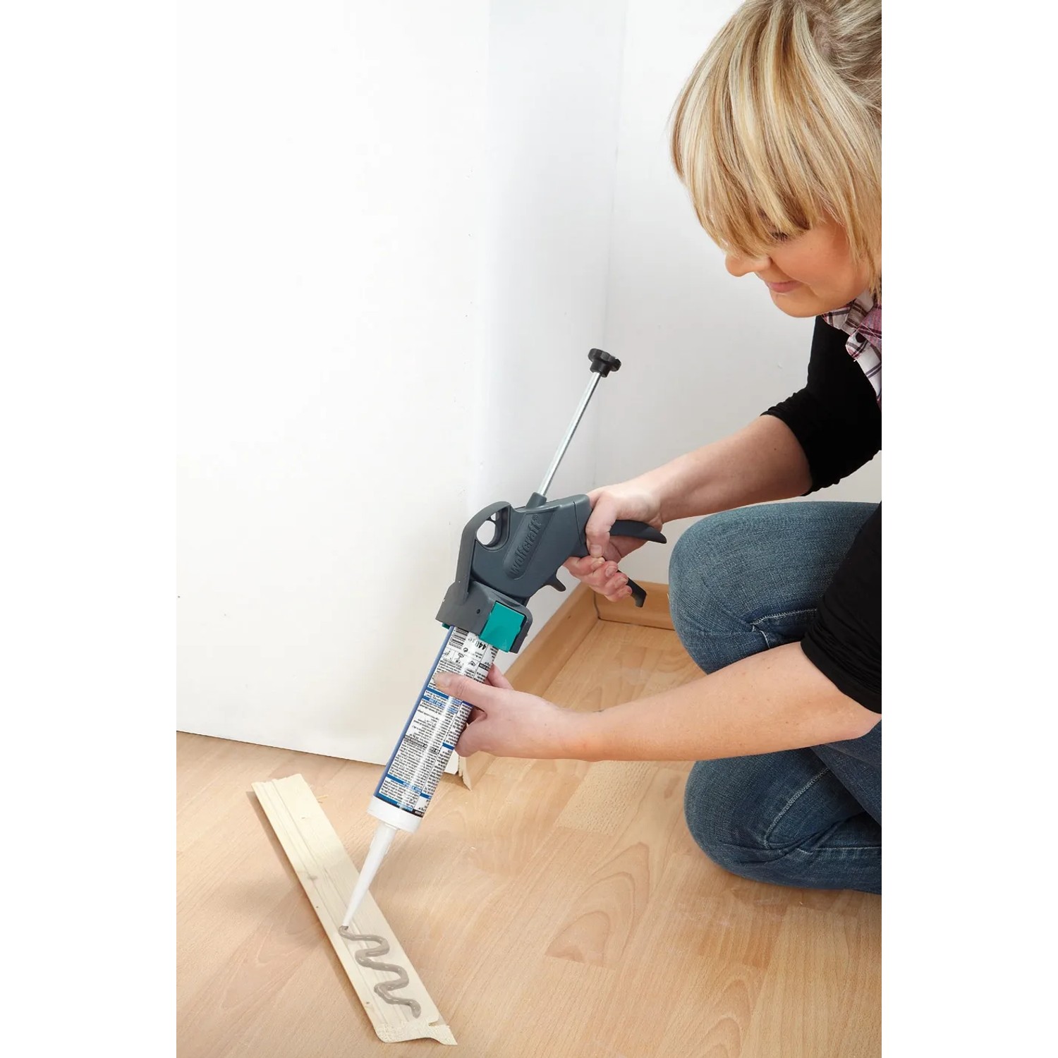 Frau benutzt wolfcraft Kartuschenpresse MG 300 für Silikon auf Holzleiste.