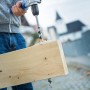 LUX Balkenbohrer Comfort im Einsatz: Bohren eines Holzstücks mit einer Bohrmaschine. Holzbohrer mit Gewindespitze.