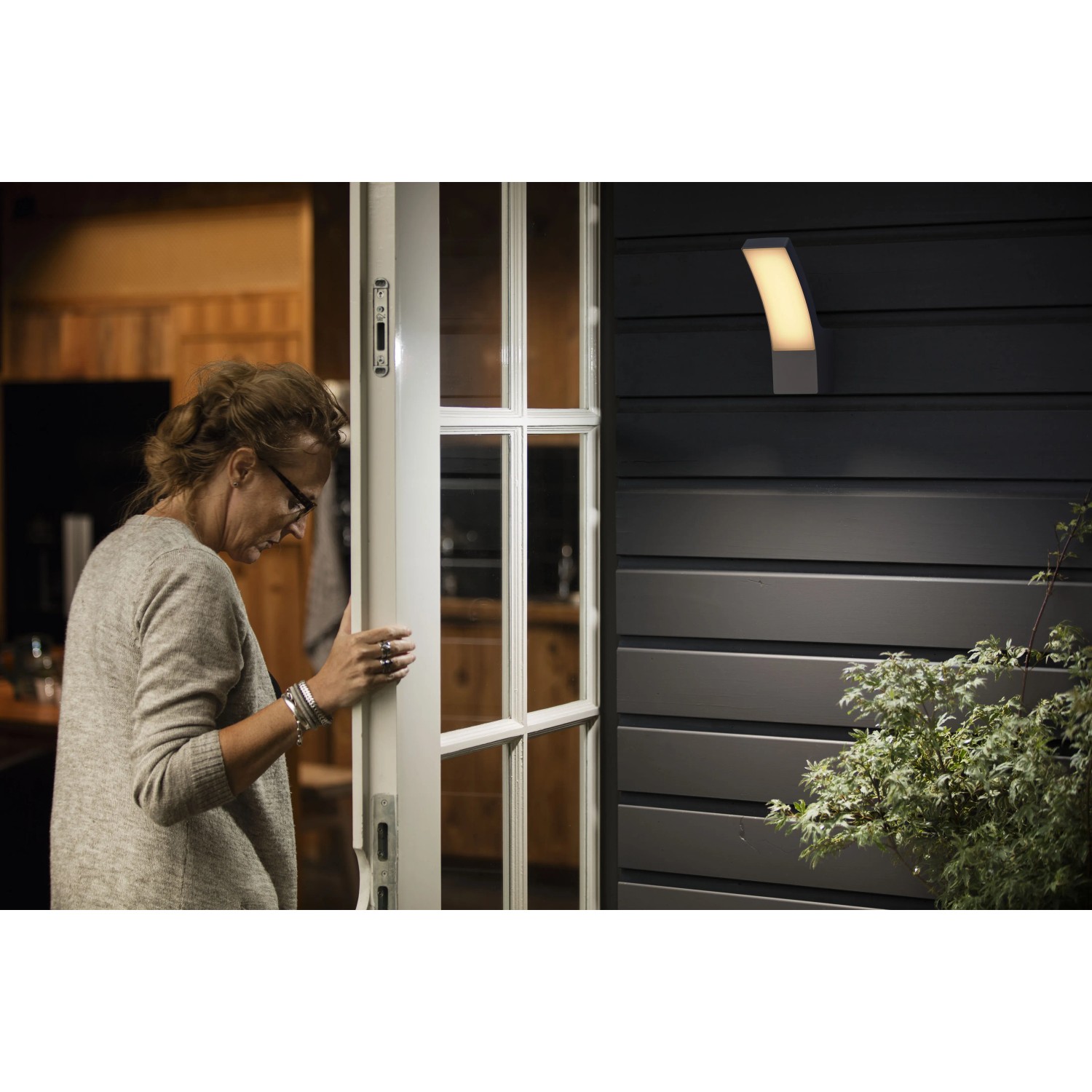 Anthrazitfarbene Philips Splay LED Aussenwandleuchte mit warmweissem Licht an dunkler Hauswand.