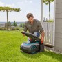 Gardena Garage für Mähroboter Sileno city/life: Mann öffnet das Dach der Mähroboter-Garage.