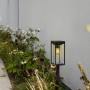 Lutec LED Solar Wegeleuchte Flair, mattschwarz, im Garten zwischen Pflanzen.