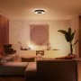 Schwarze Philips Hue Infuse L Deckenleuchte mit Farbwiedergabe im Wohnzimmer.