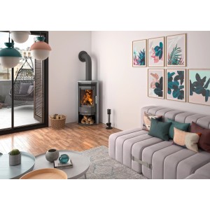 Justus Kaminofen Usedom 5 mit Speckstein in Wohnraum-Szene. Gussgrauer Ofen mit Holzscheiten im Fach.