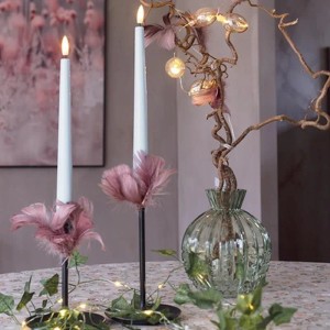 Zwei blaue LED Stabkerzen mit warmweißer 3D Flamme und Timerfunktion in schwarzen Haltern, dekoriert.