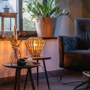 Ländliche QAZQA Tischlampe Canna Diamond aus Bambus mit warmem Licht auf Beistelltisch im Wohnzimmer.