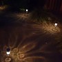 Mehrere beleuchtete LED Solar Wegleuchten aus Edelstahl mit Erdspieß im Garten bei Nacht. Dekoratives Licht für Wege.