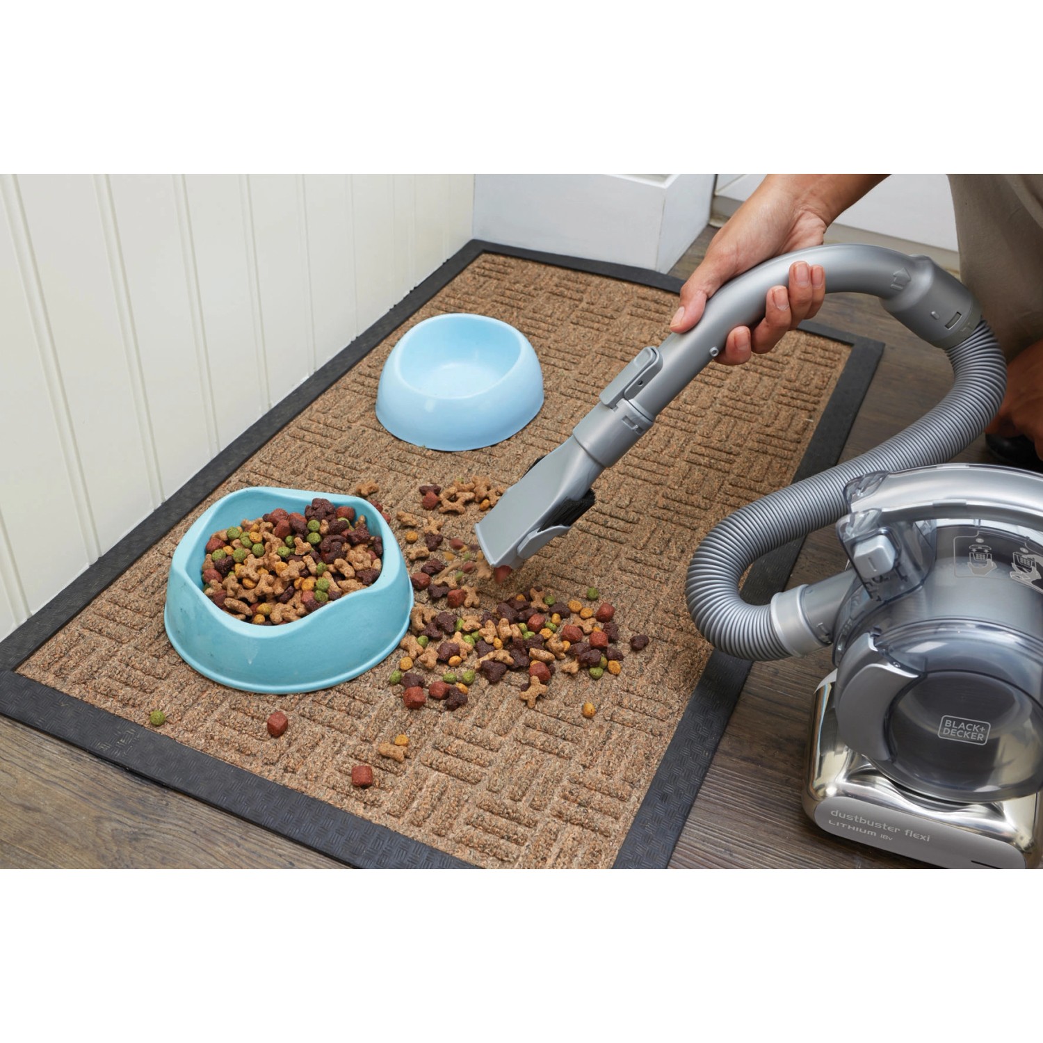 Black+Decker Dustbuster Flexi Akku-Handsauger beim Aufsaugen von Tierfutter auf einer Fußmatte.