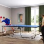 Blaue SPORTNOW Tischtennisplatte, klappbar mit Netz und Rollen, zwei Personen spielen.