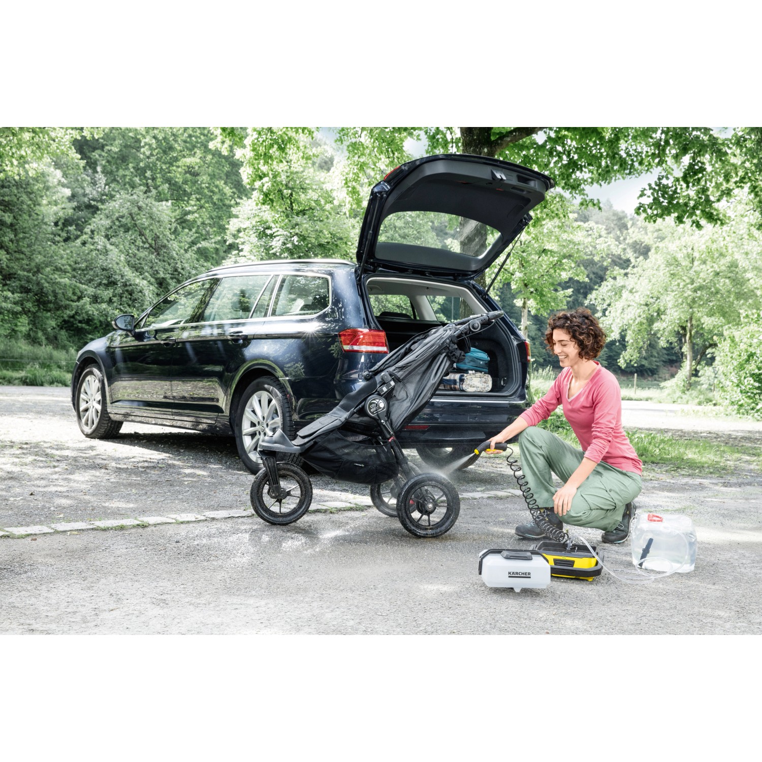 Kärcher OC 3 Adventure Zubehörbox im Einsatz: Frau reinigt Kinderwagen mit Hochdruckreiniger am Auto.