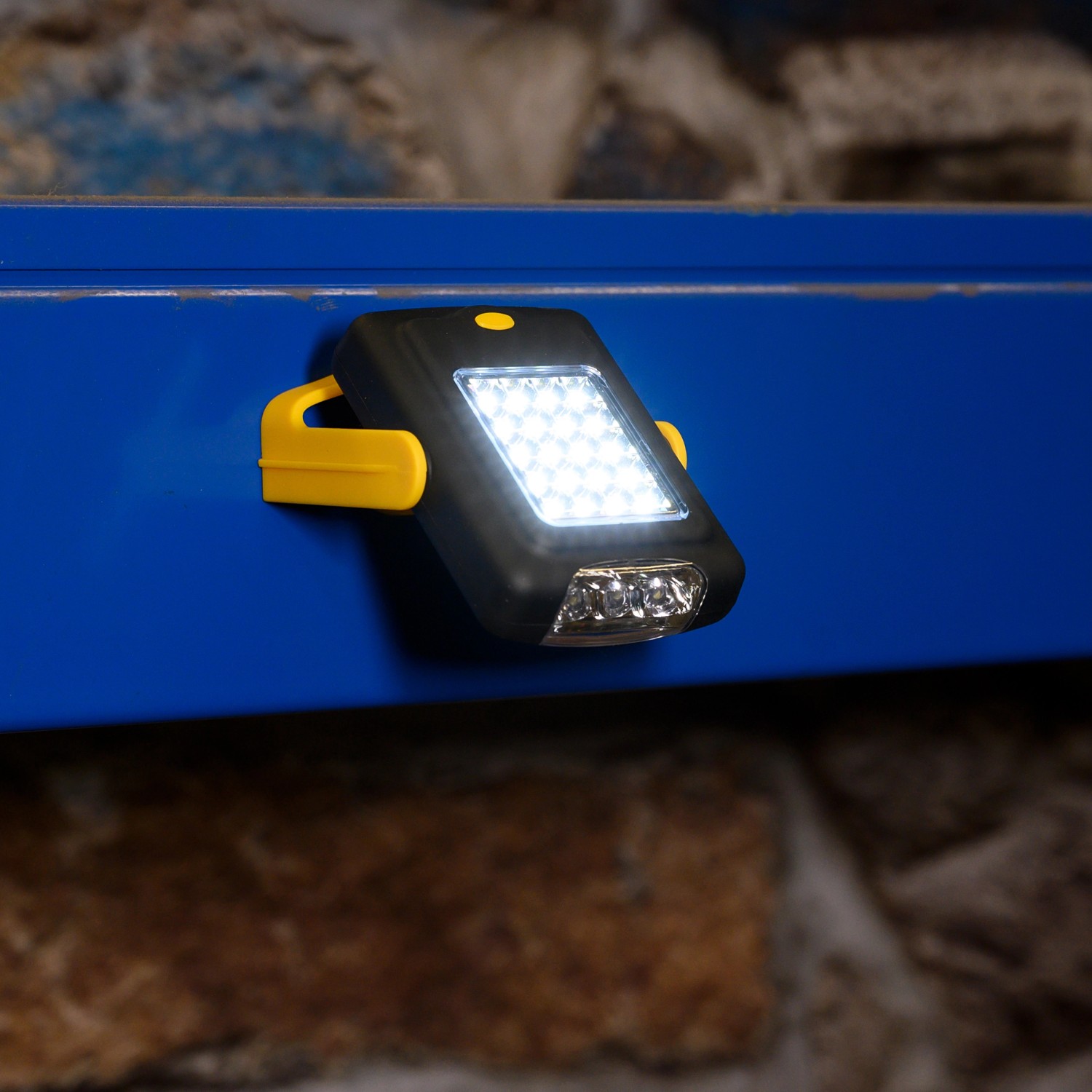 LED's Work LED-Handlampe, Baustrahler mit Magnet und Haken, befestigt an einer blauen Metalloberfläche.