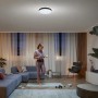 Schwarze Philips Hue Enrave L Deckenleuchte mit Dimmer in Wohnraum-Szene.