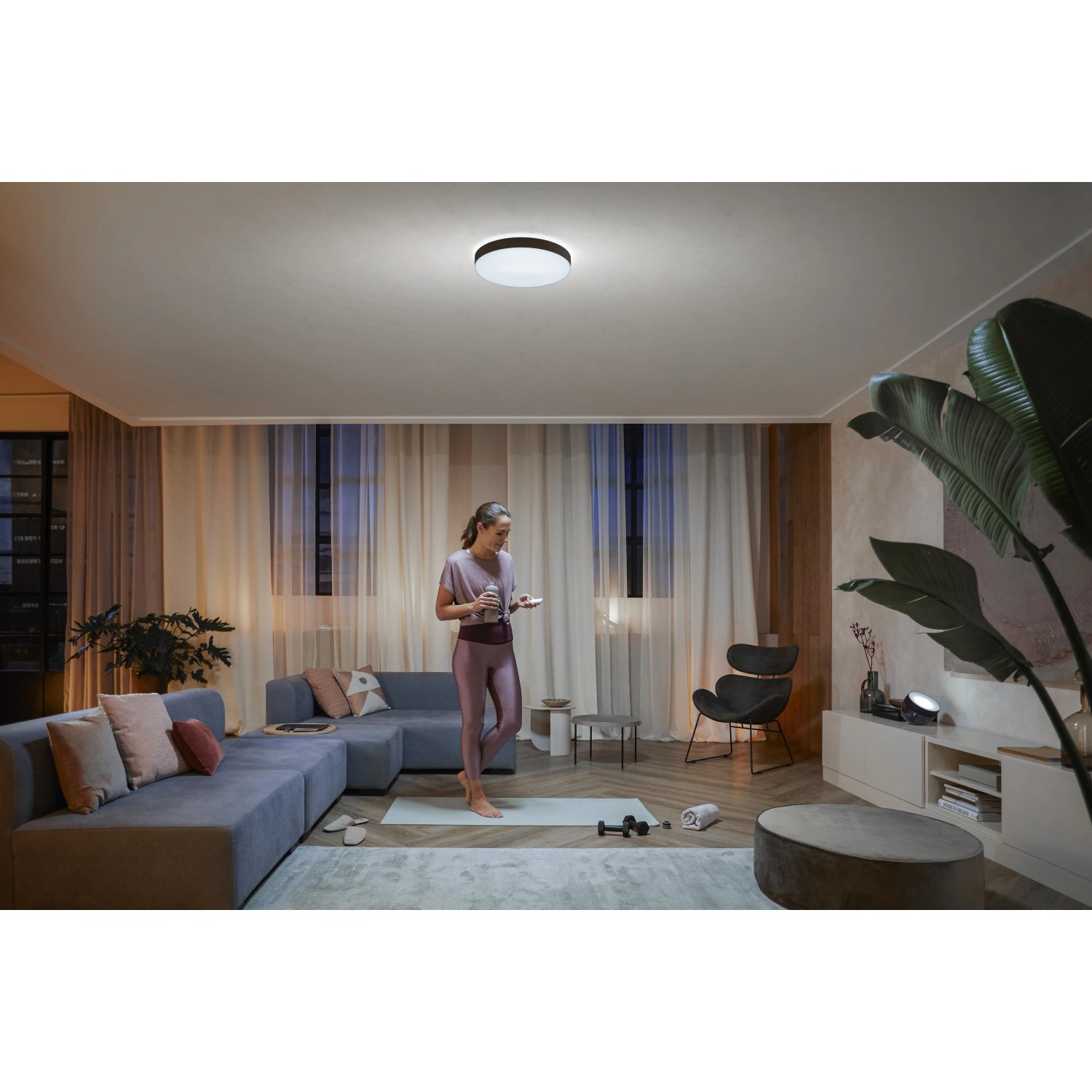 Schwarze Philips Hue Enrave L Deckenleuchte mit Dimmer in Wohnraum-Szene.