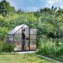 Graues Palram Canopia Gewächshaus 3,4 m² mit Fundamentrahmen im Garten.