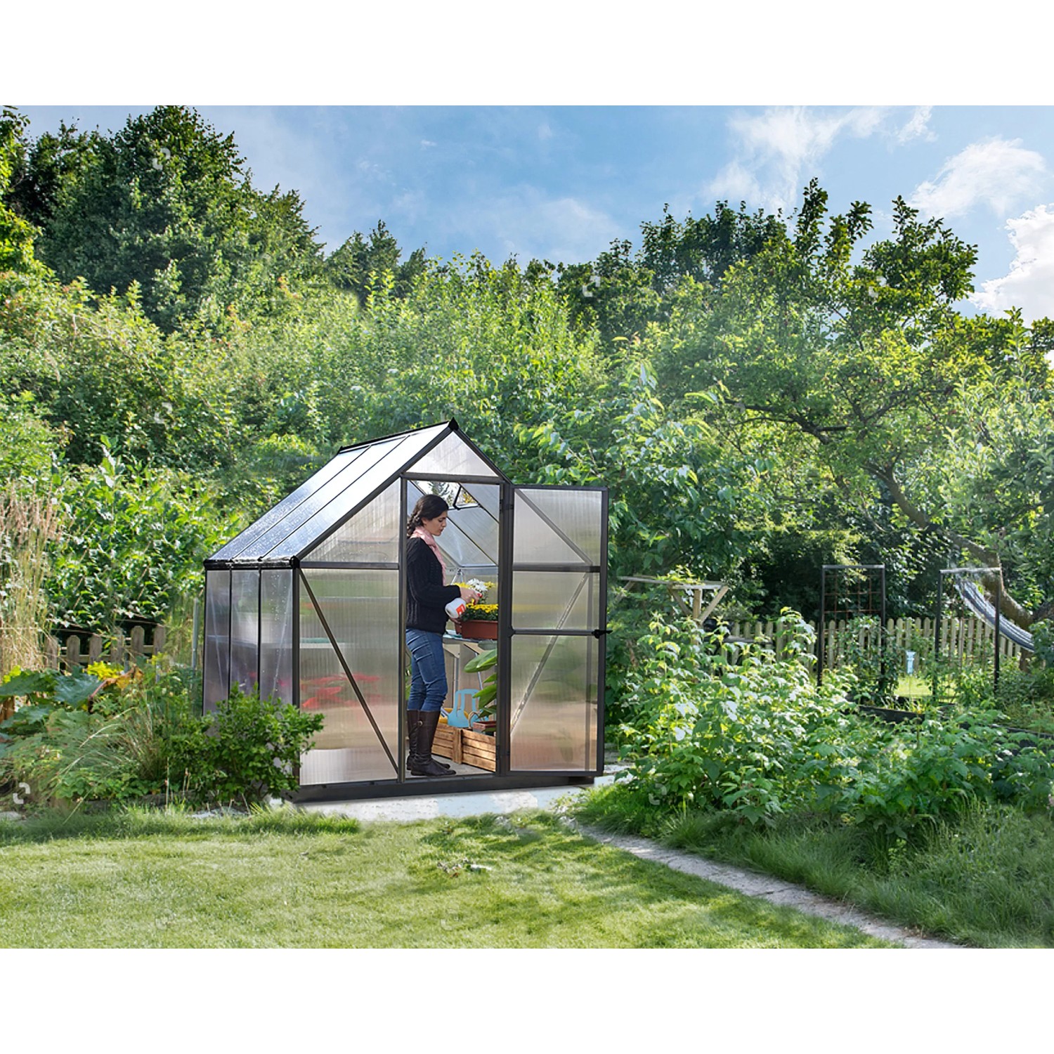 Graues Palram Canopia Gewächshaus 3,4 m² mit Fundamentrahmen im Garten.