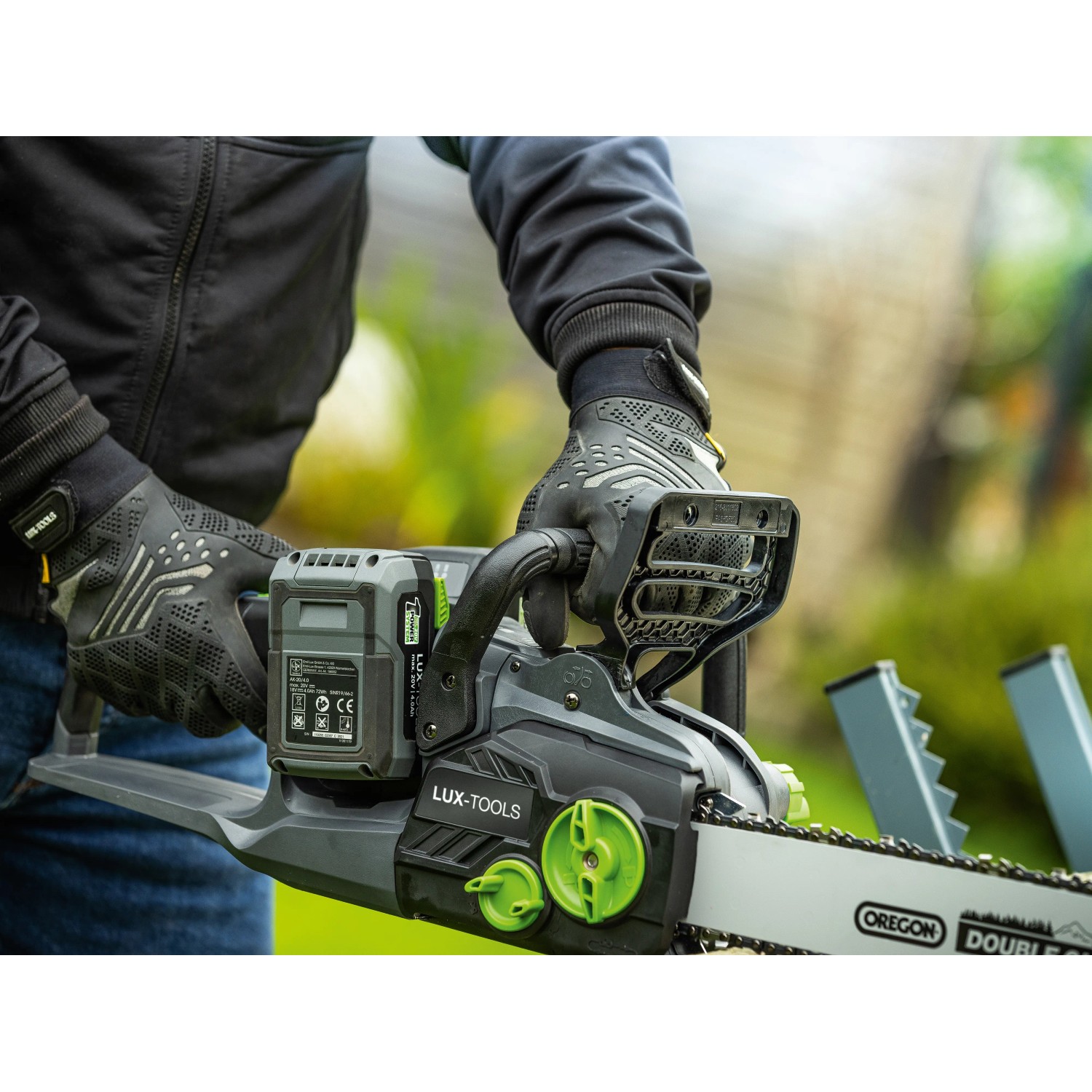 LUX-TOOLS Akku-Kettensäge A-KS-2x20/405 im Einsatz, graues Gehäuse, grüne Details, mit Akku.