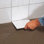 Fliesen verlegen mit Knauf Bau- & Fliesenkleber Grau 20kg. Detailaufnahme der Anwendung.