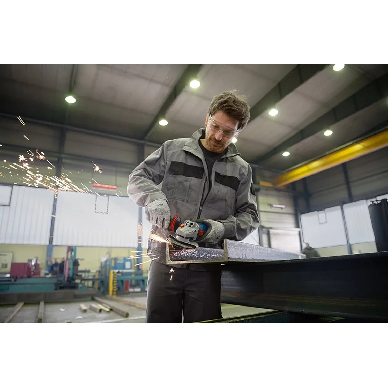 Mann schleift Metall mit dem Bosch Professional Winkelschleifer GWS 14-125 Solo.