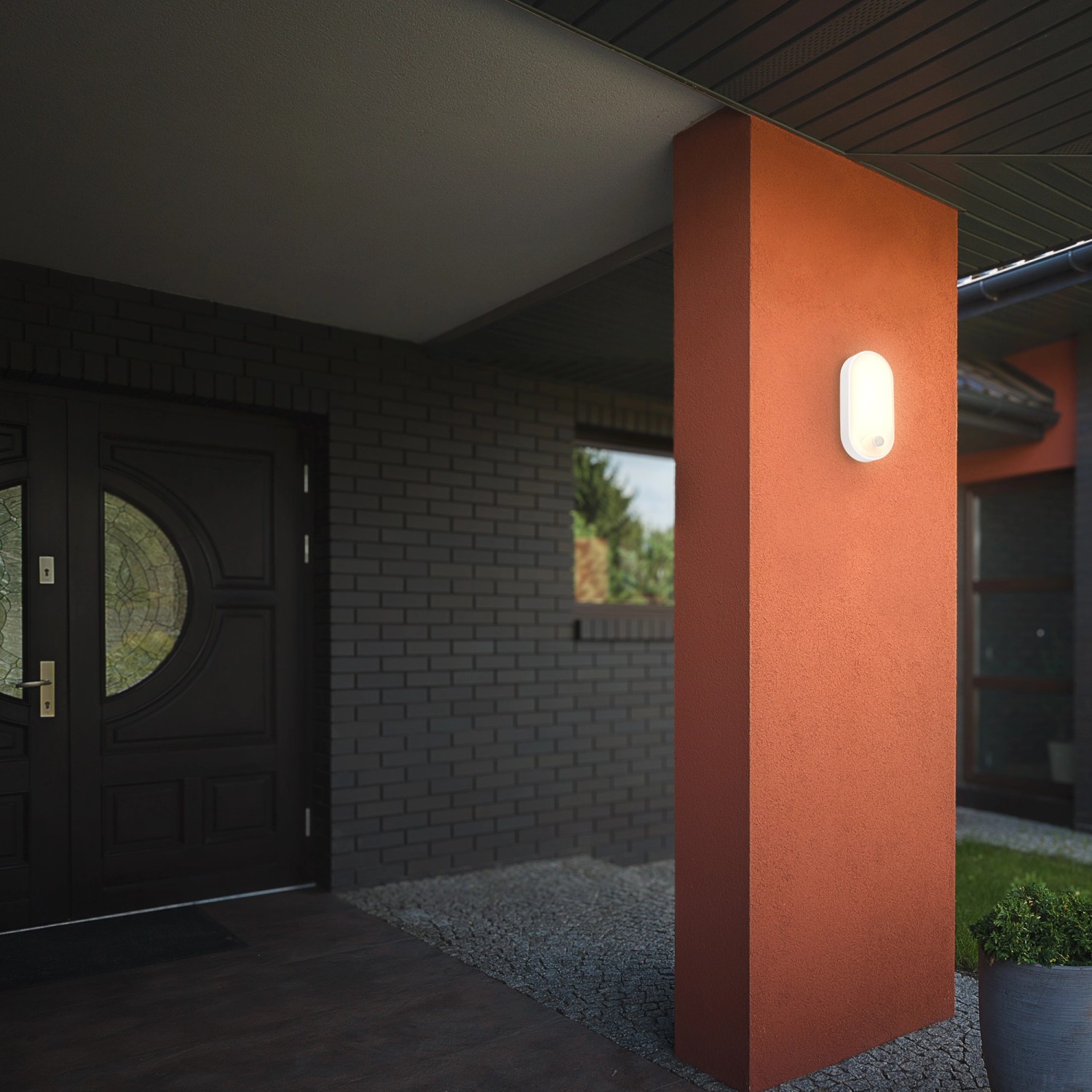 Weiße Briloner LED Wandleuchte mit Bewegungsmelder an einer Hauswand.