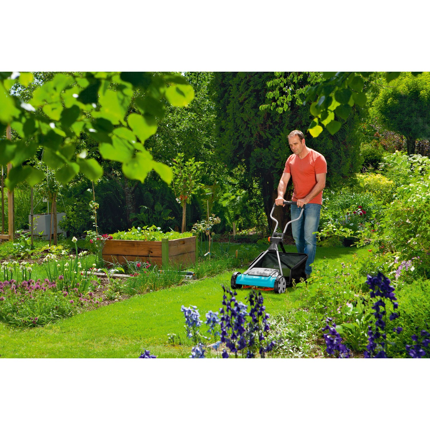 Mann mäht Rasen mit Gardena Comfort Spindelmäher 400 C im Garten.