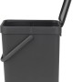 Grauer Brabantia Abfallbehälter Sort & Go, 16 l, mit offenem Deckel und Wandhalterung.