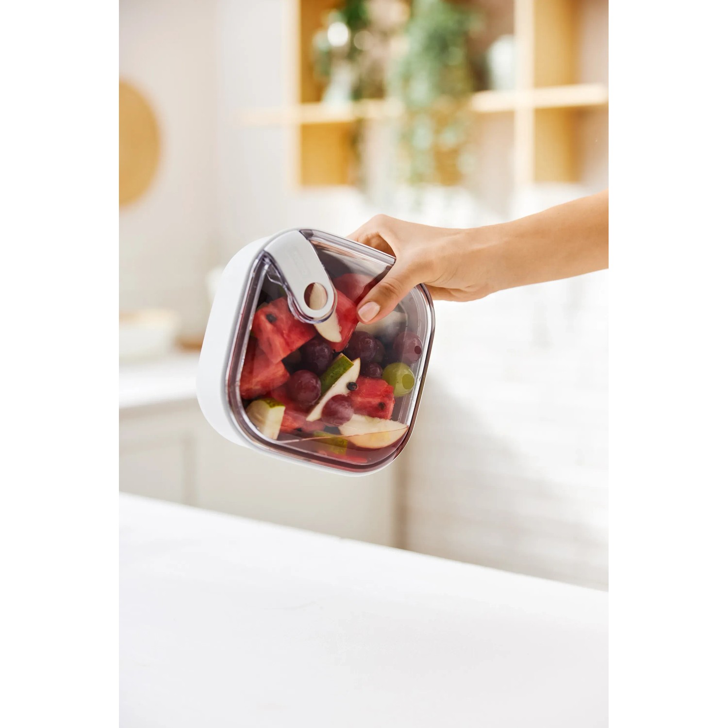 Weiße Rotho Frischhaltedose Ela 1 l mit Obst gefüllt in der Hand gehalten.