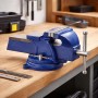 Blauer Wiltec Schraubstock mit 150mm Klemmbacken und Amboss auf einer Holzwerkbank. Robustes Spannwerkzeug.